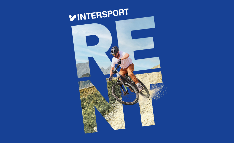 Ein Radfahrer mit Helm fährt mit einem Mountainbike auf einem Feldweg. Auf blauem Grund steht in großen Buchstaben „RENT“ und darüber „INTERSPORT“.
